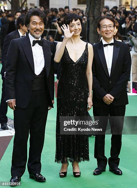 Japan - Japanese actor Koji Yakusho, actress Tamiyo Kusakari and her husband and film director Masayuki Suo stand on the green carpet, made of...