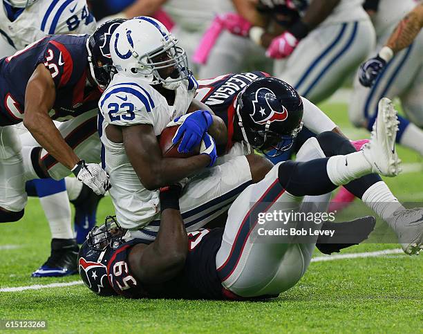 Frank Gore of the Indianapolis Colts is tackled by Whitney Mercilus of the Houston Texans and Eddie Pleasant in the fourth quarter at NRG Stadium on...