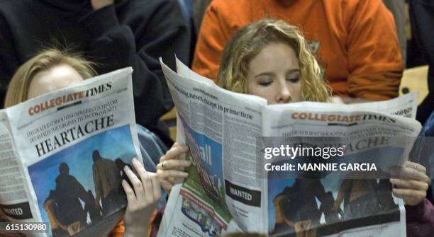 Virginia Tech students read the school newspaper prior to the start of an convocation in Cassell Coliseum at Virginia Tech in Blacksburg, Virginia,...