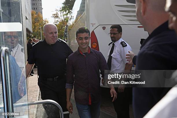 Boy is escorted after stepping off a coach at the Home Offices Lunar House after arriving from the Calais 'Jungle Camp' on October 17, 2016 in...