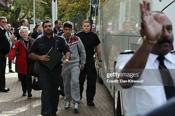 Boy is escorted after stepping off a coach at the Home Offices Lunar House after arriving from the Calais 'Jungle Camp' on October 17, 2016 in...