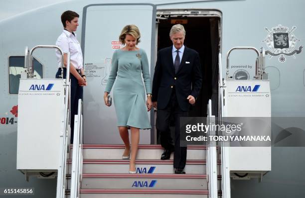 Belgian King Philippe and Queen Mathilde alight from their aircraft upon arrival at Haneda Airport in Tokyo on October 10, 2016. The Belgian royal...