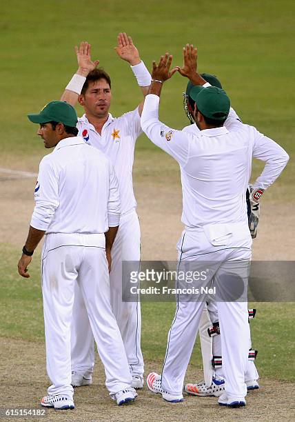 Yasir Shah of Pakistan celebrates with his teammates after dismissing Roston Chase during of West Indies Day Five of the First Test between Pakistan...