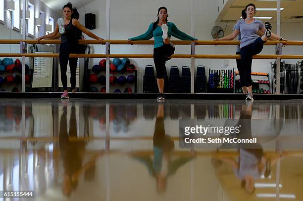 Erica DeSplinter, middle, leads Danielle Fisher, left, and Tess Bostic through a series of leg lifts during a Cardio Resistance Training class at...