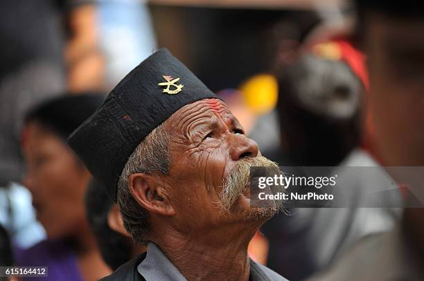 An old man observing festival as Locals carry as well as rotates top part of a chariot of Lord Narayan across the streets of Hadigaun during Lord...