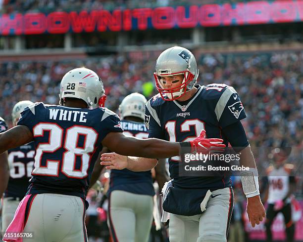 New England Patriots quarterback Tom Brady celebrates with running back James White after they hooked up for a third quarter touchdown pass, their...