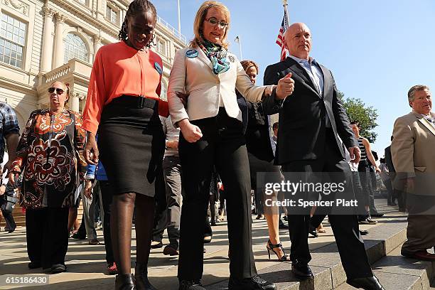 Gun violence victim and former U.S. Congresswoman Gabby Giffords walks with her husband, NASA astronaut Mark Kelly, and New York's First Lady...