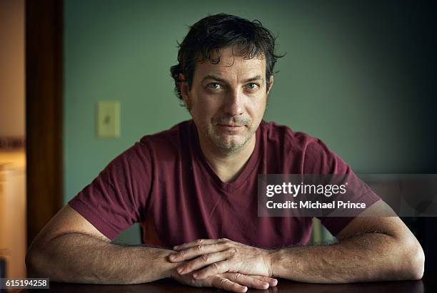 portrait of man sitting at table - suspicion stock-fotos und bilder