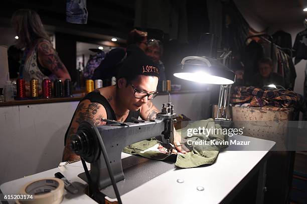 Benjamin Phillips from Lot, Stock and Barrel embroiders a jacket during Desert Trip at The Empire Polo Club on October 14, 2016 in Indio, California.