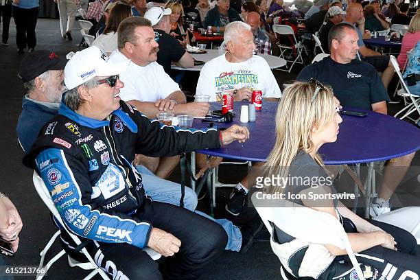 John Force and Brittany Force sit with fans while waiting to speak during a driver appearance in the Club Nitro hospitality tent during the DENSO...
