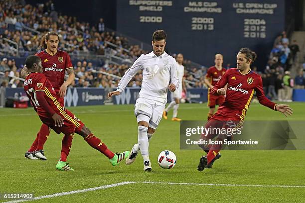 Sporting Kansas City midfielder Benny Feilhaber goes through Real Salt Lake midfielder Demar Phillips and midfielder John Stertzer in a match between...