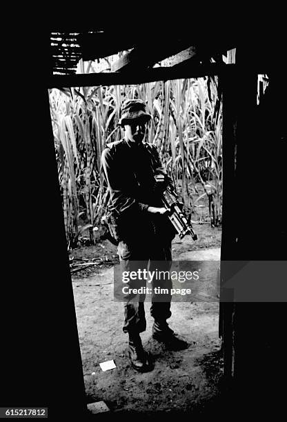 Young Australian soldier, armed with a machine gun, stands at an open door. Rung Sat, Vietnam, 1966. | Location: Rung Sat, Vietnam.