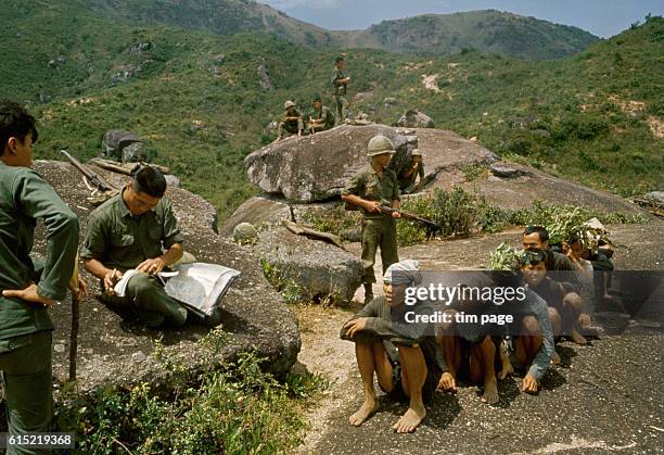 Soldiers from the Republic of Korea serving in the Vietnam War with a group of captured Vietcong prisoners. | Location: north of Bong Sen, Vietnam.