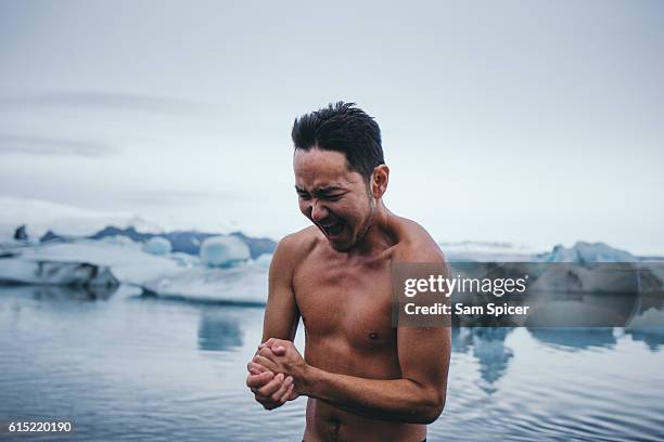 man swimming in iceberg glacier lagoon, jökulsárlón, iceland - iceberg water stock-fotos und bilder