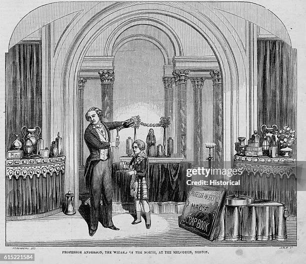 His son looks on apprehensively as Professor Anderson performs a magic trick on stage in Boston, Massachusetts. The bottle the professor holds can...