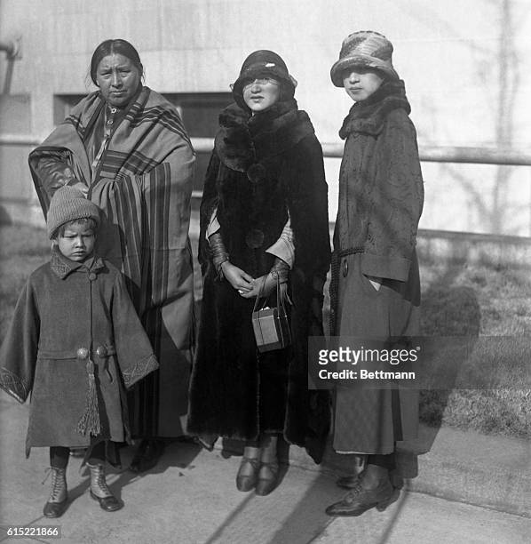 Two Indian flappers accompanied the group. Left to right in the group are Mrs. Red Eagle, Miss Rose Wagoshe, and Miss Mary Red Eagle. The child is...