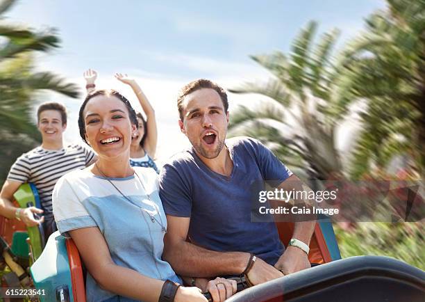 young couple cheering on amusement park ride - young woman screaming on a rollercoaster stock pictures, royalty-free photos & images