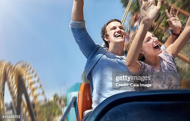 enthusiastic couple cheering and riding amusement park ride - young woman screaming on a rollercoaster stock pictures, royalty-free photos & images