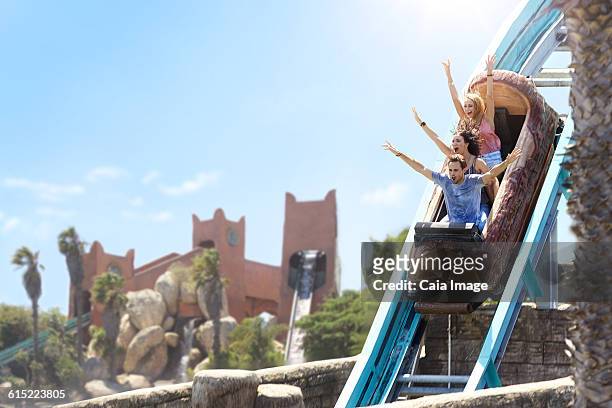 enthusiastic friends cheering on log amusement park ride - young woman screaming on a rollercoaster stock pictures, royalty-free photos & images