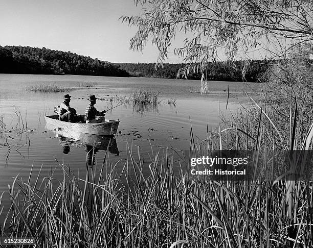 Two men fish for bass in a rowboat on Cedar Lake. Ouachita National Forest, Oklahoma, November 1960.