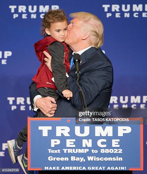 Republican presidential nominee Donald Trump kisses a child during a rally at the KI Convention Center on October 17, 2016 in Green Bay, Wisconsin. /...