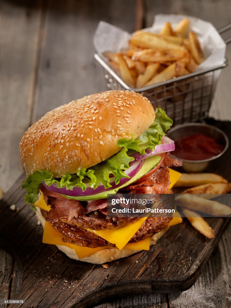 Avocado Bacon Cheeseburger with a Basket of Fries