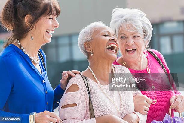 trois femmes âgées multiethniques font leurs courses - sac à main blanc photos et images de collection
