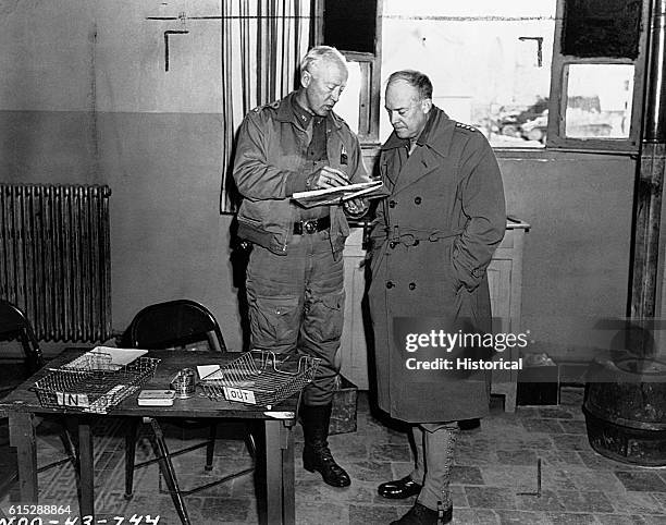 General George S. Patton confers with General Dwight Eisenhower while looking at a map. Eisenhower was Supreme Commander of Allied forces during the...