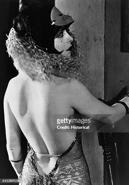 Actress Clara Bow wears a feather boa and a revealing backless dress. Bow was an American film star who beame known as the It Girl, after her role in...