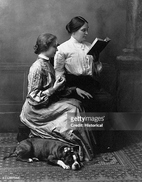 Helen Keller reads with her teacher, Anne Sullivan Macy. While Keller attended Radcliffe College, Macy helped her with her studies by reading books...