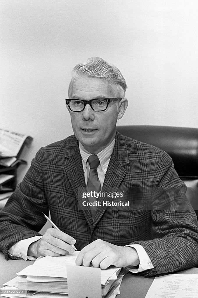 John Anderson at Desk with Pen in Hand