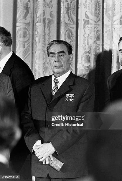 Leonid Ilich Brezhnev stands between two men. Brezhnev was a Communist party official and the head of the Soviet State from the 1960s.