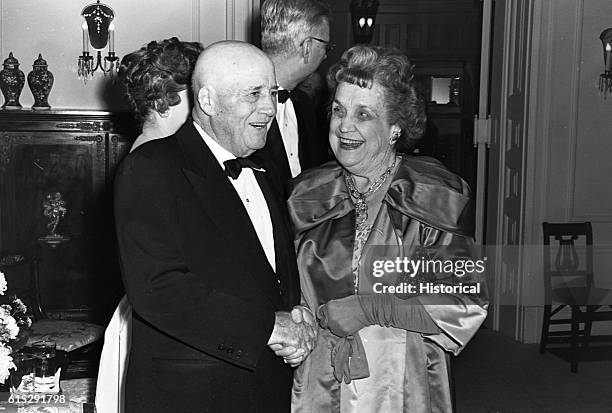 House Speaker Sam Rayburn shakes hands with Perle Mesta, U.S. Ambassador to Luxembourg, at a Washington, D.C., reception. Ca. 1950s.