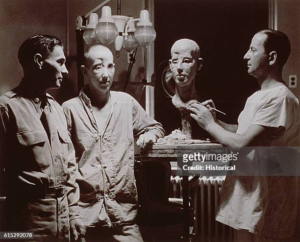 Doctor sculpts a model for the reconstruction of his patient's face, which was injured in battle. Walter Reed General Hospital.
