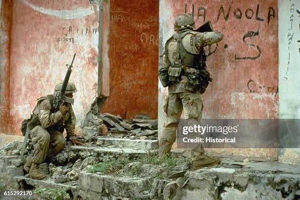 Pair of Marines from Task Force Mogadishu prepare to clear a building during a raid on a weapons cache as part of the multinational relief effort...