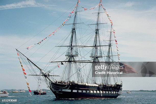 Guests fill the deck of the frigate USS Constitution during its annual turnaround cruise. The Constitution is towed into the harbor each year and...