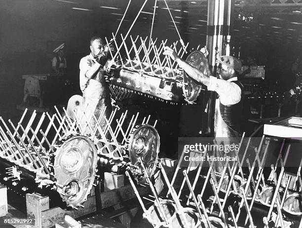 Two assembly line workers assemble Rolls Royce engines at the Packard motor car company in Detroit, Michigan. January 1943.