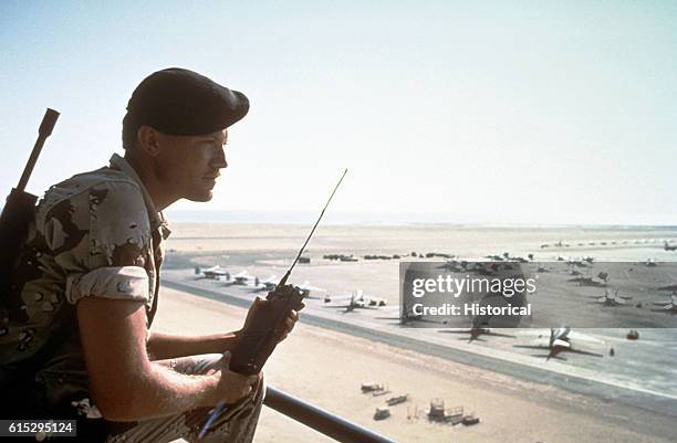 Senior Airman Will Hober of the 832nd Security Patrol Squadron, Luke Air Force Base, Arizona, stands watch with a radio at an air field in Saudi...