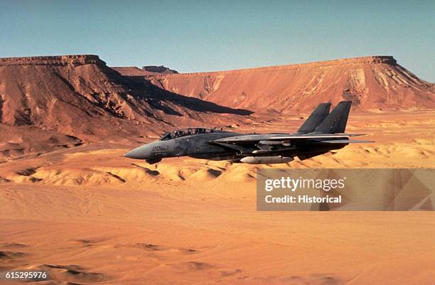 Fighter Squadron 32 F-14A Tomcat aircraft passes over the desert while on combat patrol off the aircraft carrier USS John F. Kennedy during Operation...