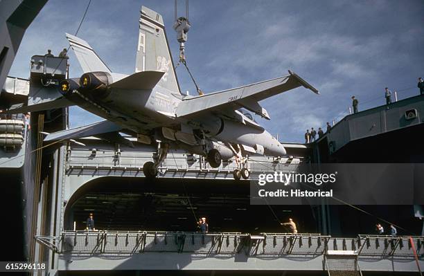 Shipboard crane lifts an F/A-18 Hornet aircraft on the nuclear-powered aircraft carrier Abraham Lincoln , at the pier a day before the carrier's...