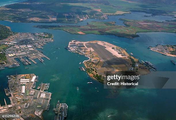 The U.S. Naval base at Pearl Harbor. The nuclear-powered aircraft carrier USS Enterprise is visible at the bottom left, while the nuclear-powered...