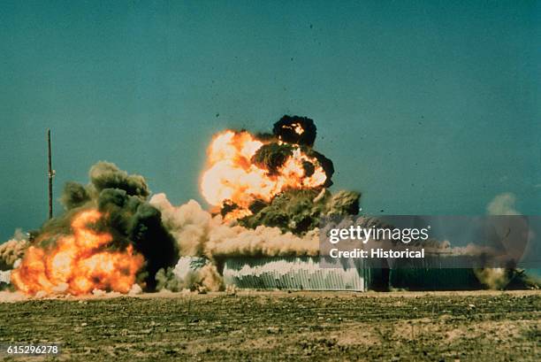 Tomahawk cruise missile, armed with a live 1,000 pound Bullpup conventional warhead, detonates and explodes its target, a warehouse-size concrete and...
