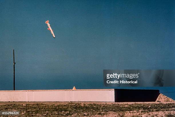 Tomahawk cruise missile, armed with a live 1,000 pound Bullpup conventional warhead, makes an approach on its target, a warehouse-size concrete and...