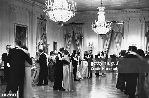 Guests dancing in the East Room of the White House. This is one of the few pictures of John F. Kennedy dancing.