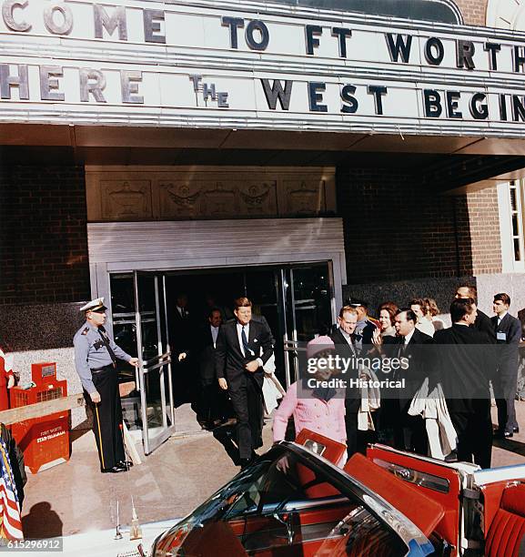 President John F. Kennedy and First Lady Jacqueline Kennedy emerge from a Fort Worth, Texas, theater, into a waiting car on the day of Kennedy's...