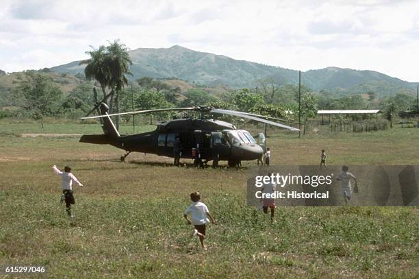 Panamanian children run to meet a UH-60 Black Hawk helicopter from Co. A, 1st Bn., 228th Aviation Regiment, that landed in a field near their village...