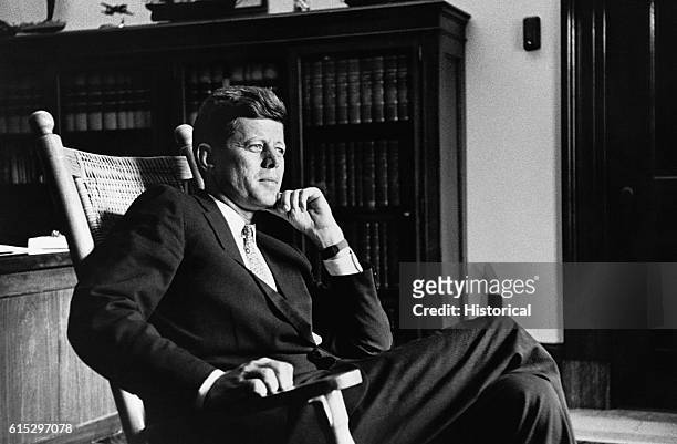 President John F. Kennedy , thirty-fifth president of the United States, relaxes in his trademark rocking chair in the Senate Office .