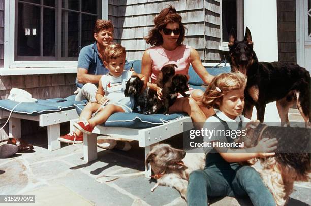 The first family on the patio of their Squaw Island House in Hyannisport, Massachusetts, with several puppies and dogs.