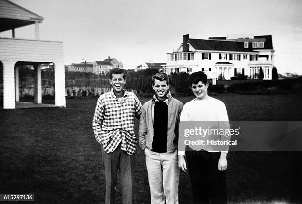 Three of the Kennedy brothers, John, Robert and Ted in their teens, stand together at their family compound in Hyannisport.