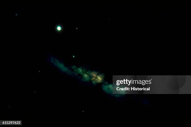 Distant photograph of M82 , an irregular galaxy. The small bright spot is another galaxy.